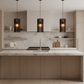 Three walnut Lattice pendants over kitchen island with sink